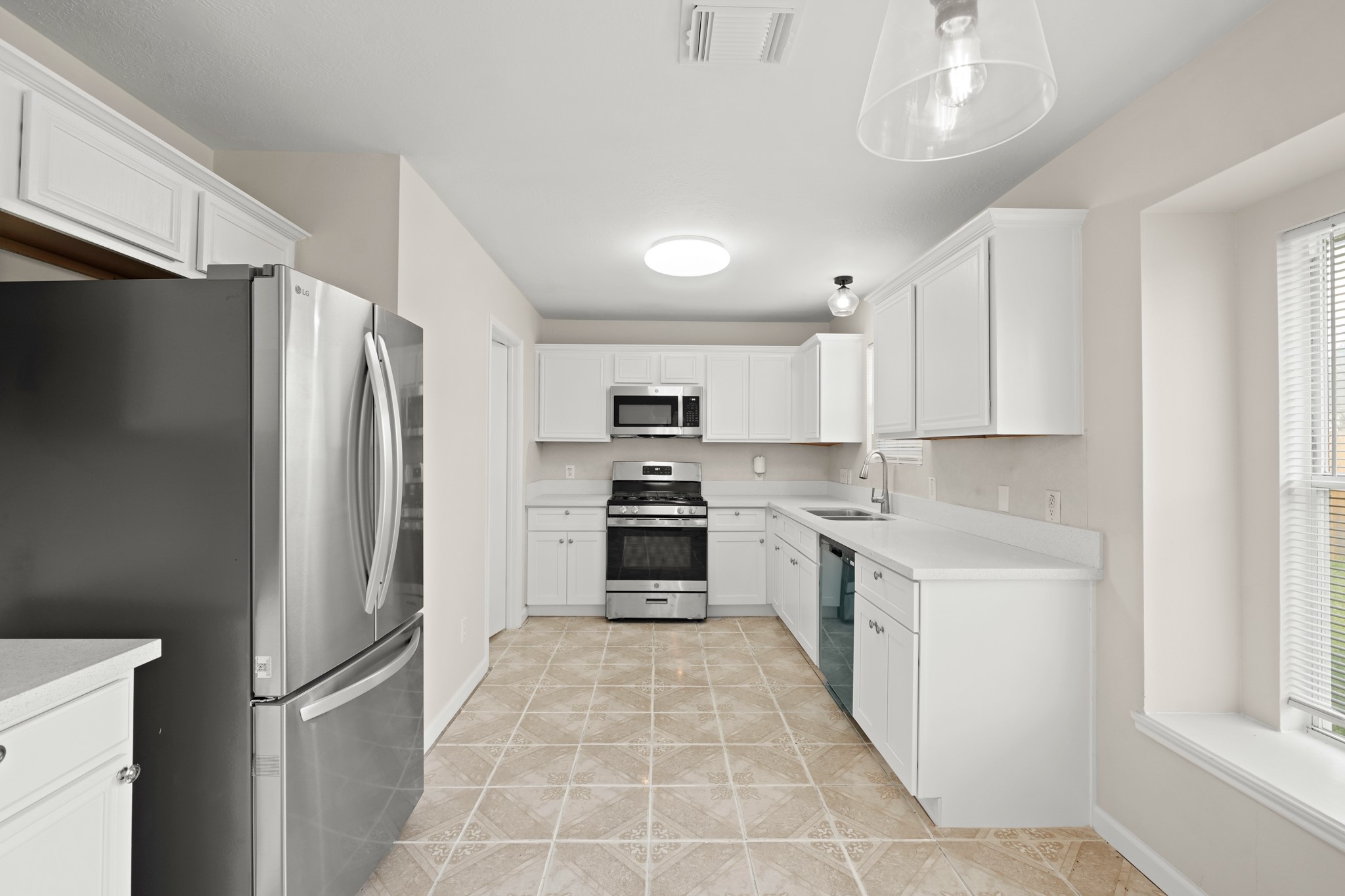 1426 Cartwright Road Missouri City, TX 77489 - Photo 9 of 26 a large kitchen with cabinets and stainless steel appliances