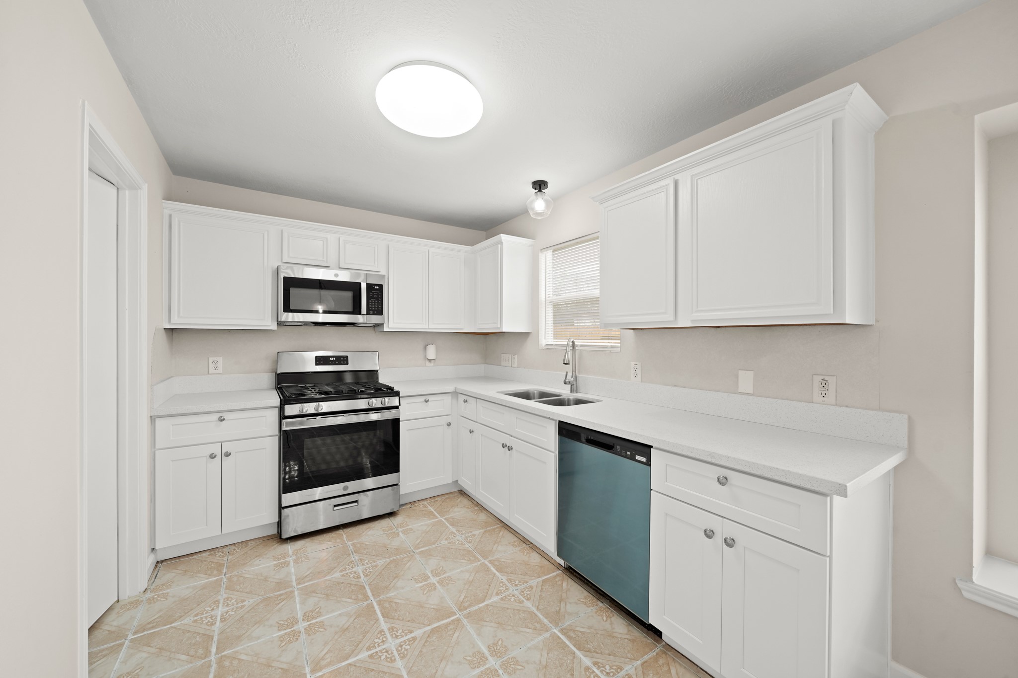 1426 Cartwright Road Missouri City, TX 77489 - Photo 10 of 26 a kitchen with stainless steel appliances granite countertop a sink dishwasher stove and white cabinets