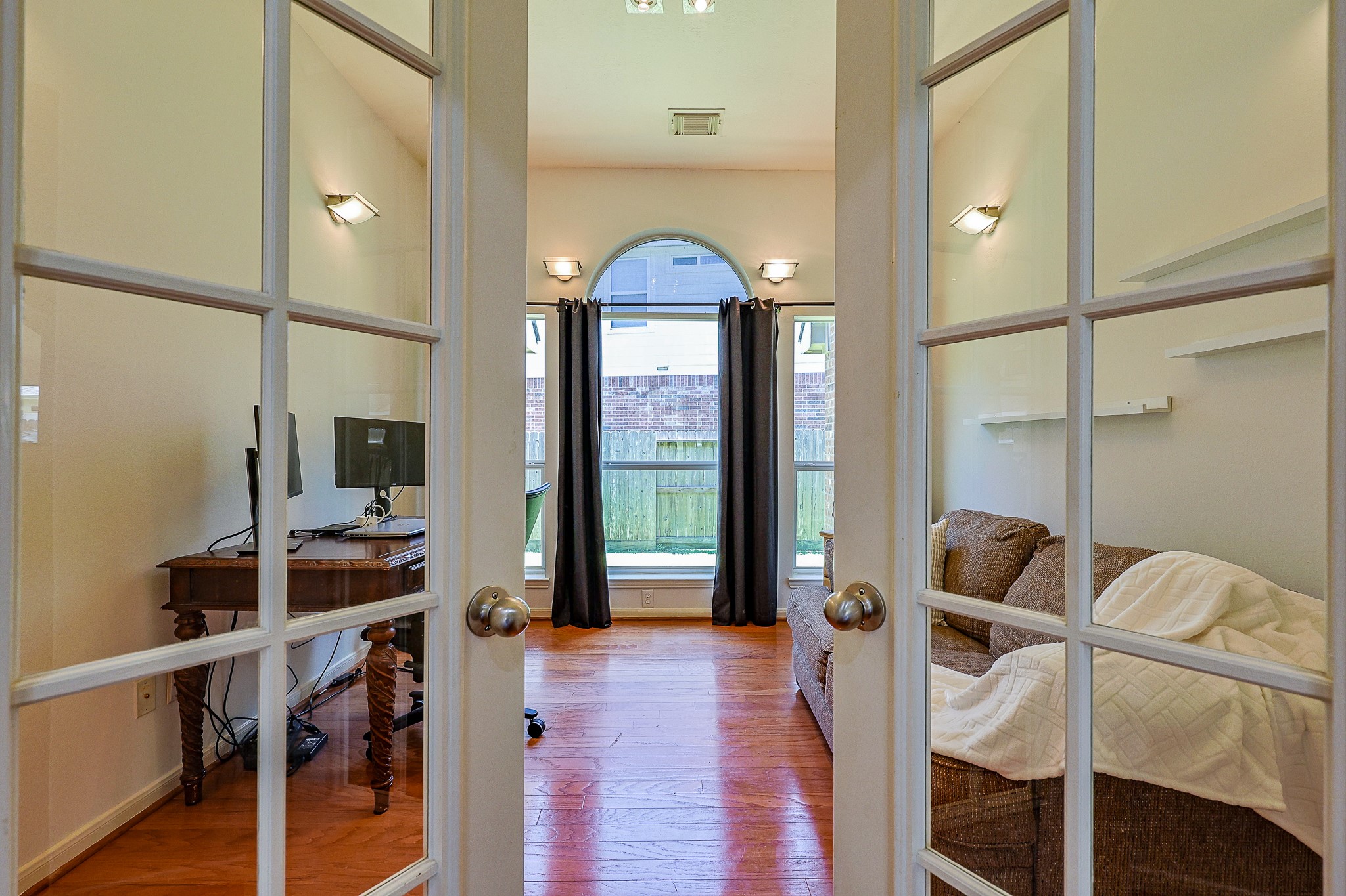 10306 Rudolph Court Missouri City, TX 77459 - Photo 9 of 34 French Doors creates an elegant entry into this private study/office for focused work. This study/office features wood flooring, custom sconce lighting and built-in shelving on each side of the french doors. Large windows flood the room with light.