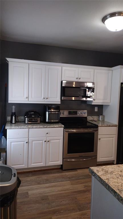 136 Hill Street Commerce, GA 30529 - Photo 14 of 27 a kitchen with stainless steel appliances kitchen island granite countertop a stove a sink and a microwave