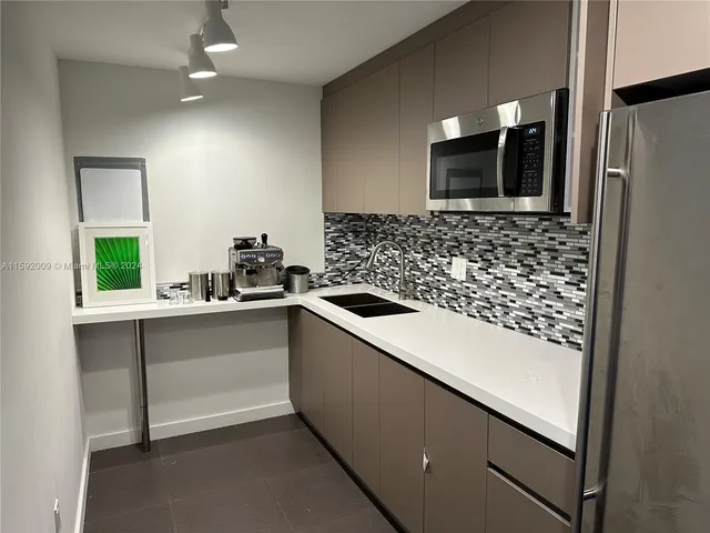 a kitchen with a sink and a refrigerator