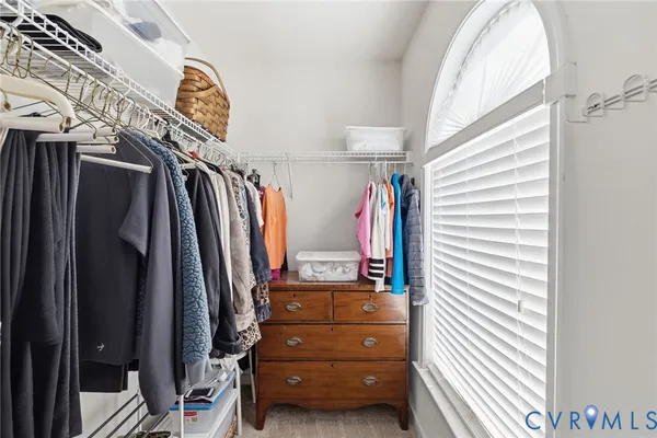a view of walk in closet with clothes and shoes