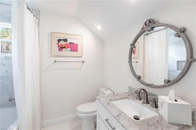 a bathroom with a granite countertop toilet a sink and a mirror