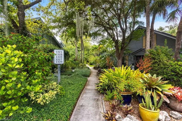 a front view of a house with a yard and potted plants