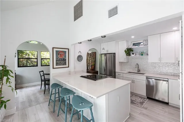 a kitchen with stainless steel appliances a table and chairs in it