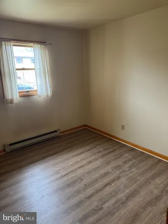 a view of a room that has wooden floor and windows in it