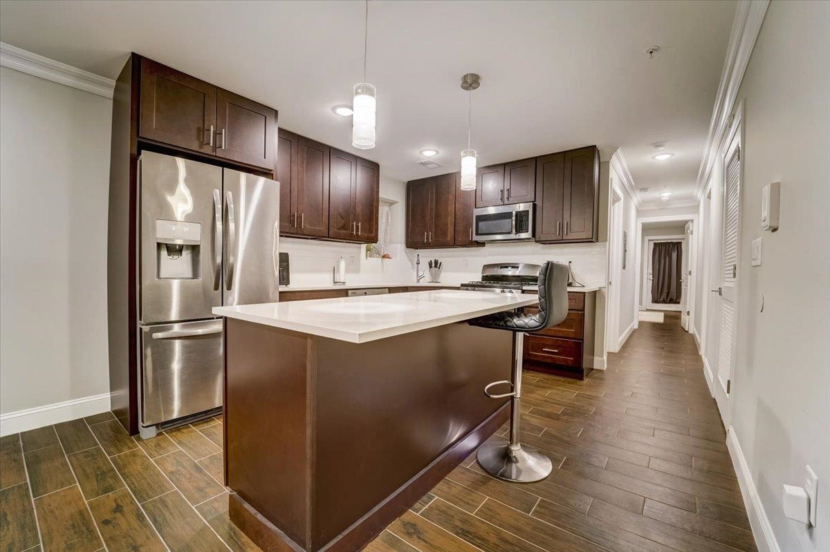 2765 John F. Kennedy Boulevard, Unit 1 Jersey City, NJ 07306 - Photo 11 of 33 a kitchen with kitchen island granite countertop stainless steel appliances cabinets a sink and a counter top space