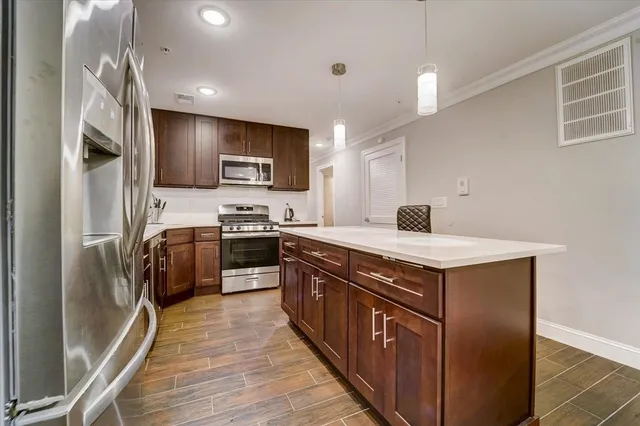 a kitchen with stainless steel appliances a stove a sink and a refrigerator