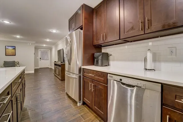 a kitchen with a sink stainless steel appliances a counter top space and cabinets