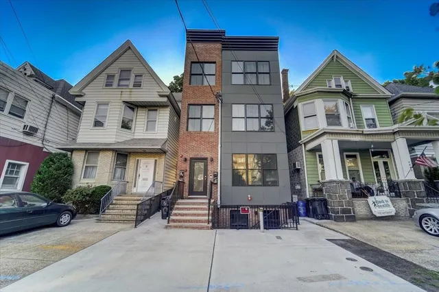 a front view of a residential apartment building with a yard