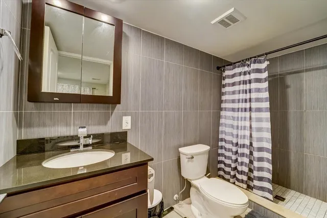 a bathroom with a sink toilet vanity and shower