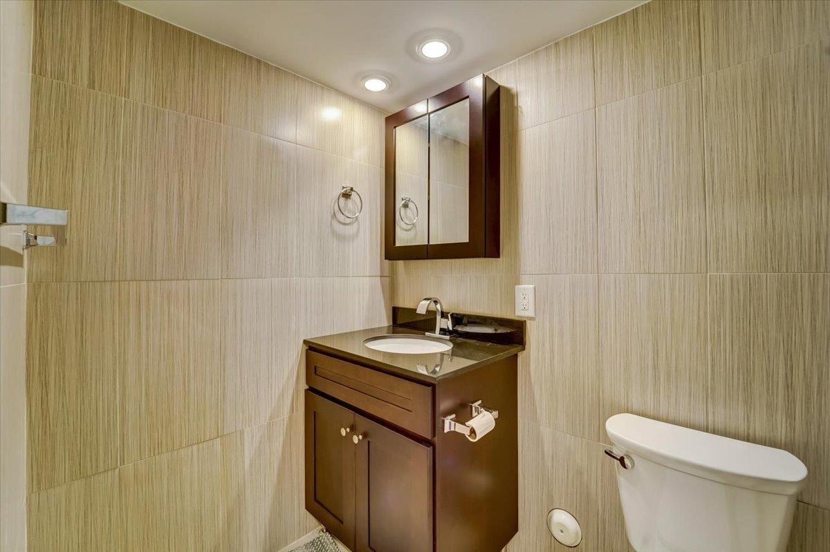 2765 John F. Kennedy Boulevard, Unit 1 Jersey City, NJ 07306 - Photo 25 of 33 a bathroom with a granite countertop sink toilet and mirror