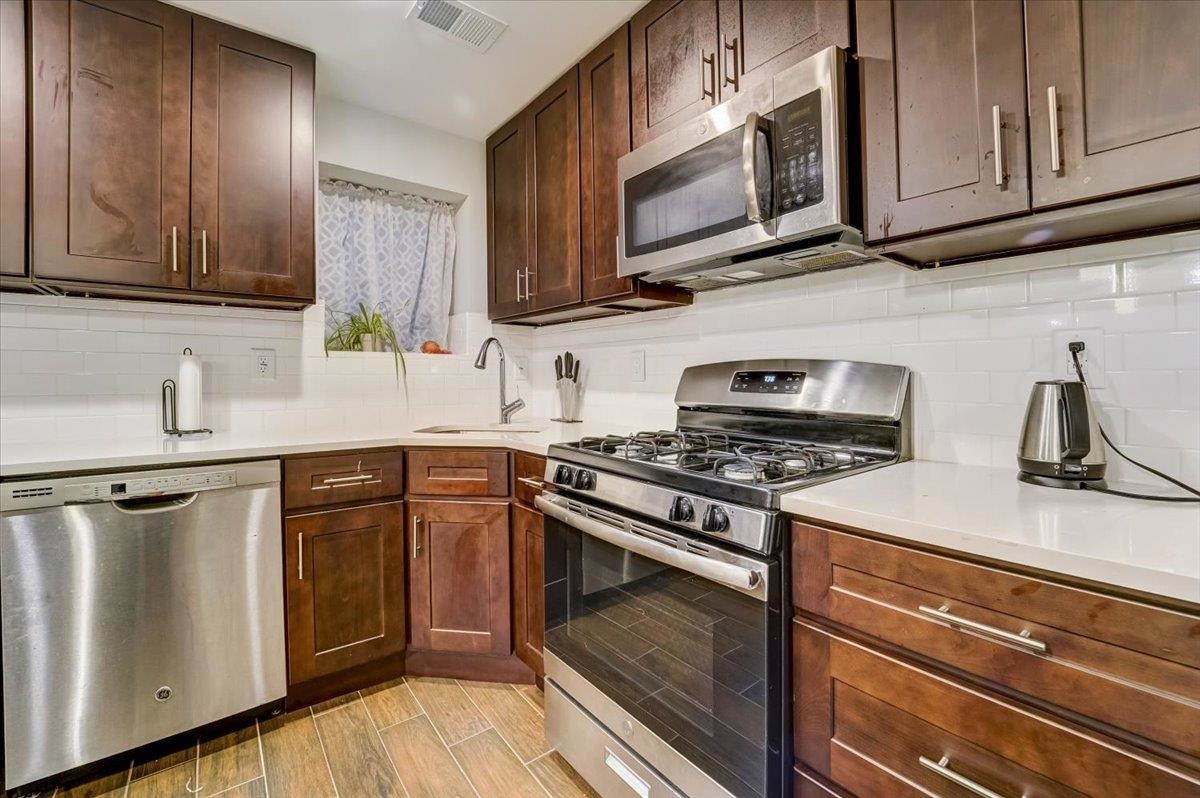 2765 John F. Kennedy Boulevard, Unit 1 Jersey City, NJ 07306 - Photo 10 of 33 a kitchen with stainless steel appliances granite countertop a sink stove and microwave