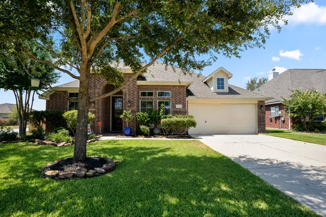 a front view of a house with a yard and tree