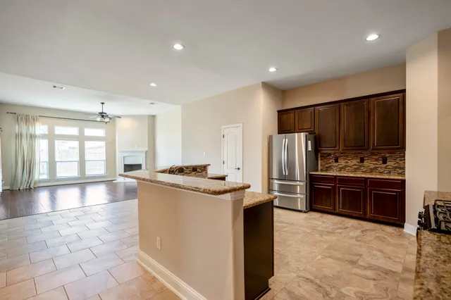 a kitchen with stainless steel appliances granite countertop a stove refrigerator and a sink