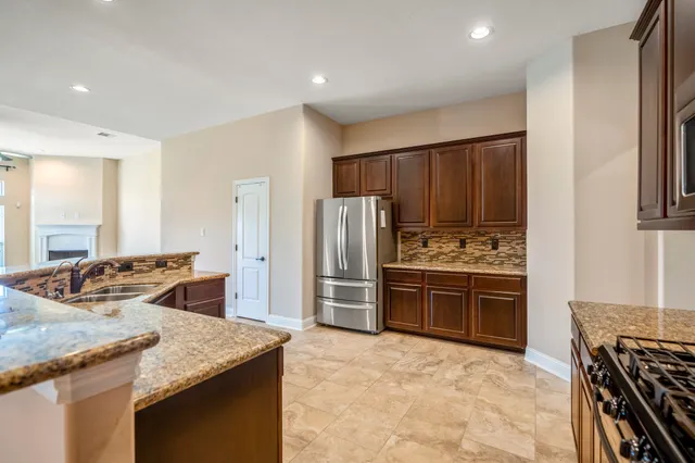 a kitchen with stainless steel appliances granite countertop a sink stove and refrigerator