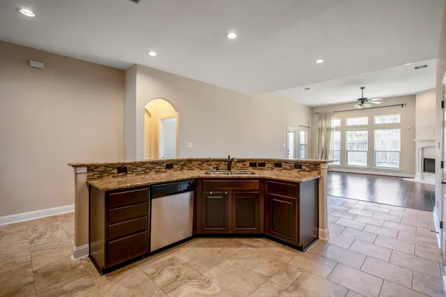 a large kitchen with stainless steel appliances granite countertop a stove and a sink
