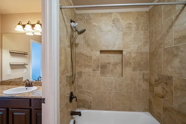 a bathroom with a granite countertop sink and a mirror