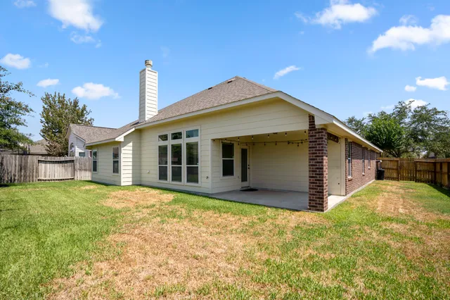 a view of a house with backyard and sitting area