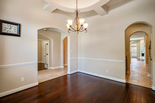a view of a room with wooden floor a ceiling fan and kitchen space