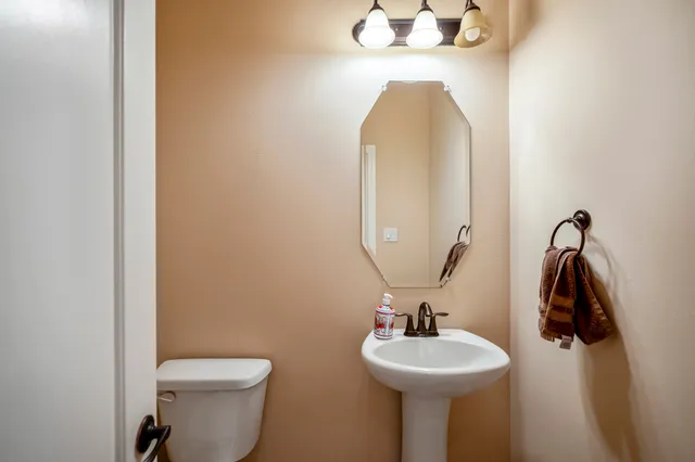 a bathroom with a sink mirror and toilet