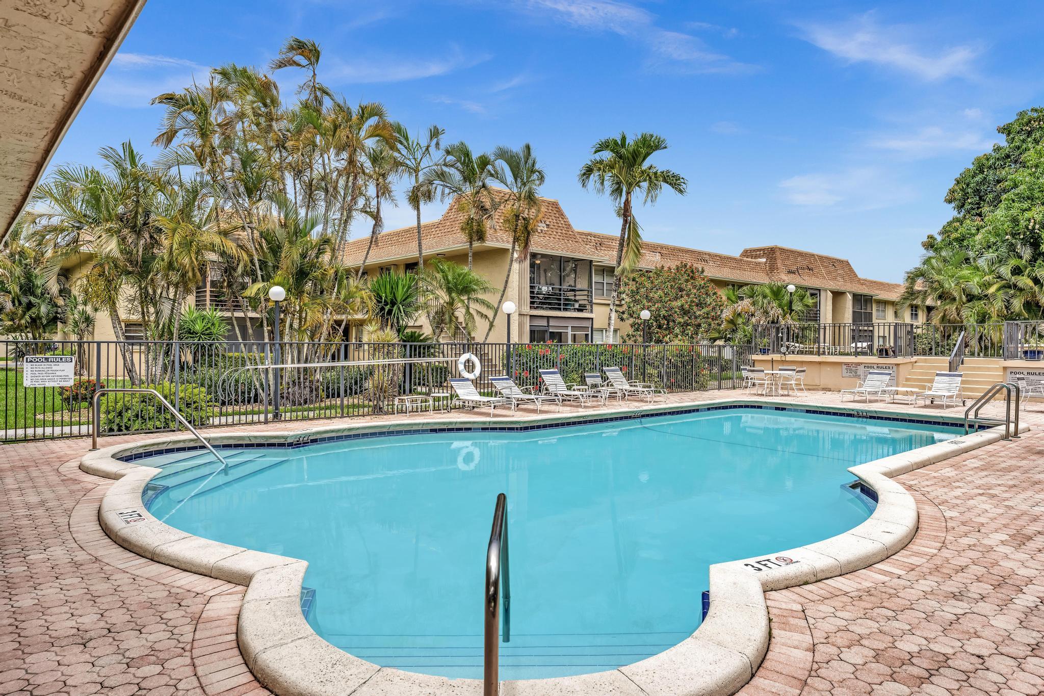 1291 Northwest 13th Street, Unit 445D Boca Raton, FL 33486 - Photo 2 of 50 a view of a swimming pool with a patio