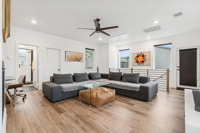 a living room with furniture ceiling fan and a wooden floor