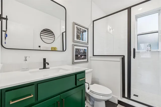 a bathroom with a sink a mirror a toilet and a shower