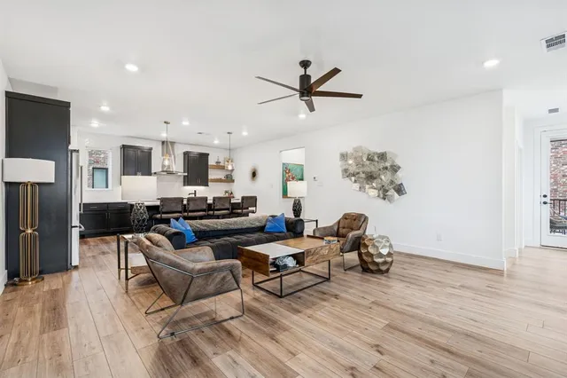 a living room with furniture and a wooden floor