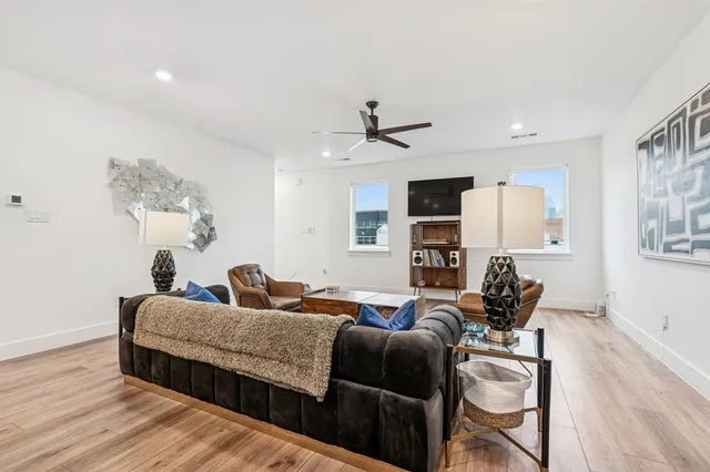 a living room with furniture and a wooden floor