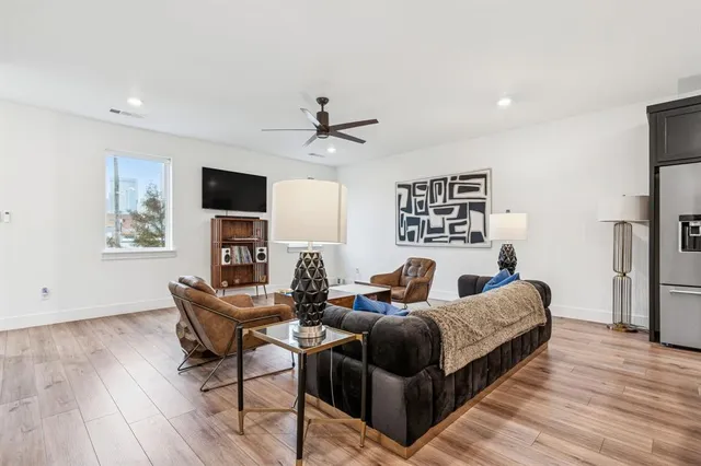 a living room with furniture a flat screen tv and a fireplace