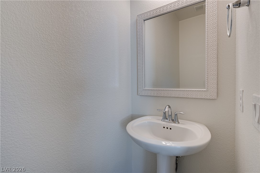 5954 Smith Valley Road Las Vegas, NV 89148 - Photo 12 of 23 A compact pedestal sink offers efficient space usage in this powder room.