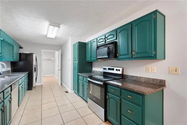 a kitchen with stainless steel appliances granite countertop a stove a sink and a microwave