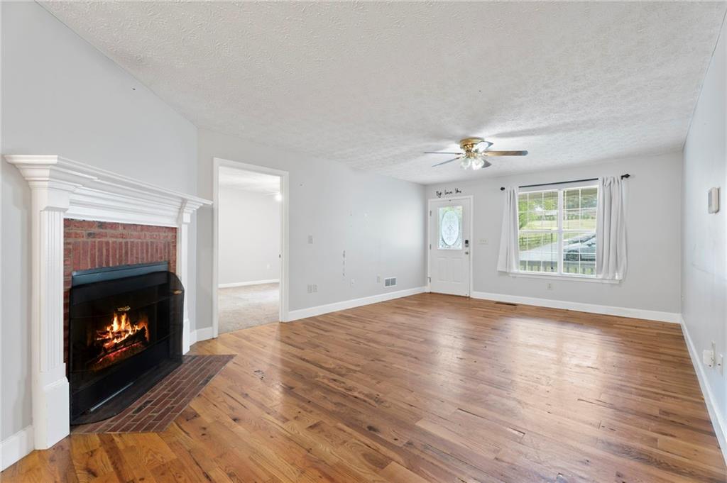 6854 John West Road Winston, GA 30187 - Photo 7 of 46 a view of an empty room with wooden floor fireplace and a window