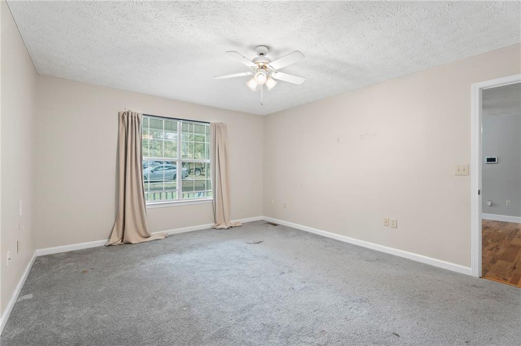 6854 John West Road Winston, GA 30187 - Photo 9 of 46 an empty room with a ceiling fan and window