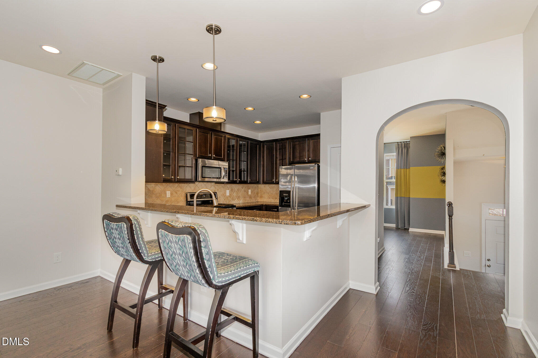 9142 Falkwood Road Raleigh, NC 27617 - Photo 8 of 33 a kitchen with stainless steel appliances a table and chairs in it