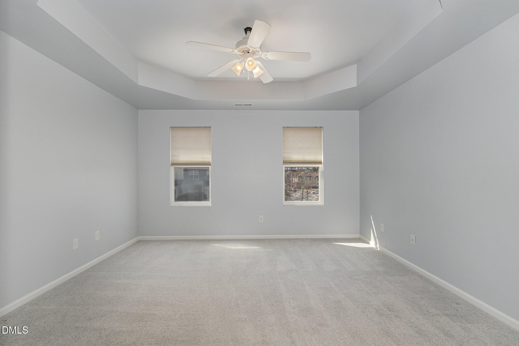 9142 Falkwood Road Raleigh, NC 27617 - Photo 22 of 33 an empty room with a chandelier fan and windows