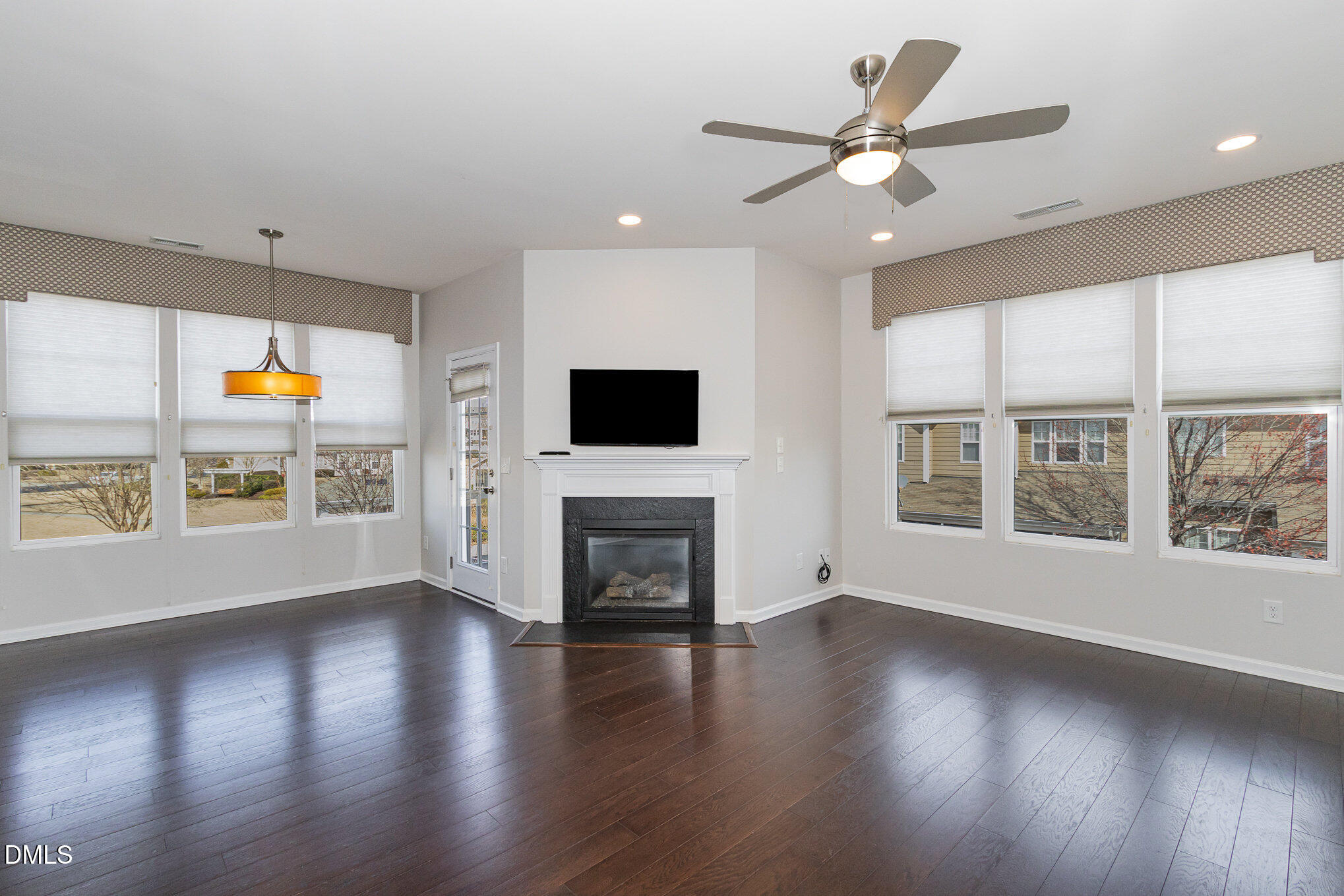 9142 Falkwood Road Raleigh, NC 27617 - Photo 5 of 33 an empty room with windows fireplace and wooden floor