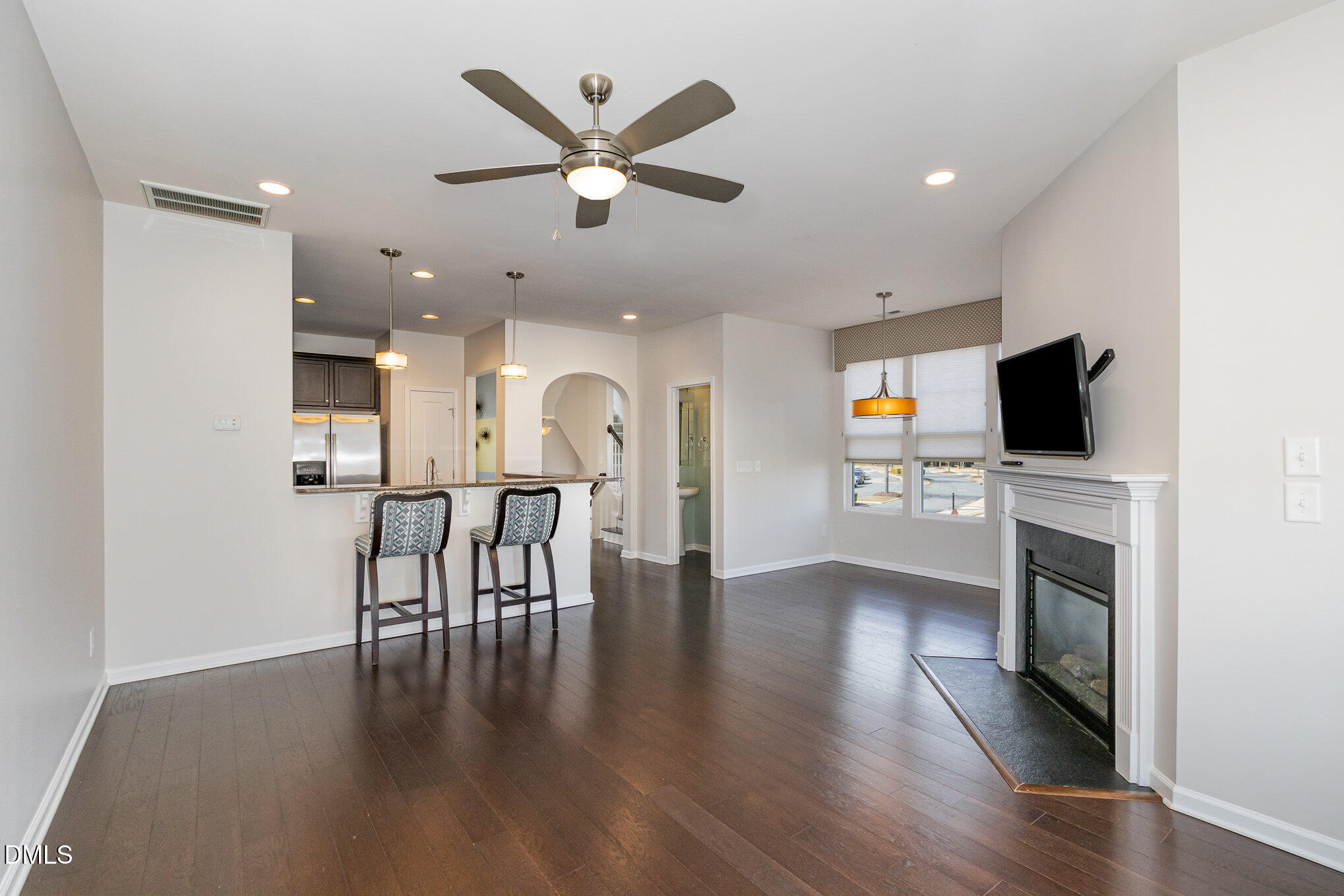 9142 Falkwood Road Raleigh, NC 27617 - Photo 6 of 33 a view of a livingroom with kitchen and fireplace with wooden floor