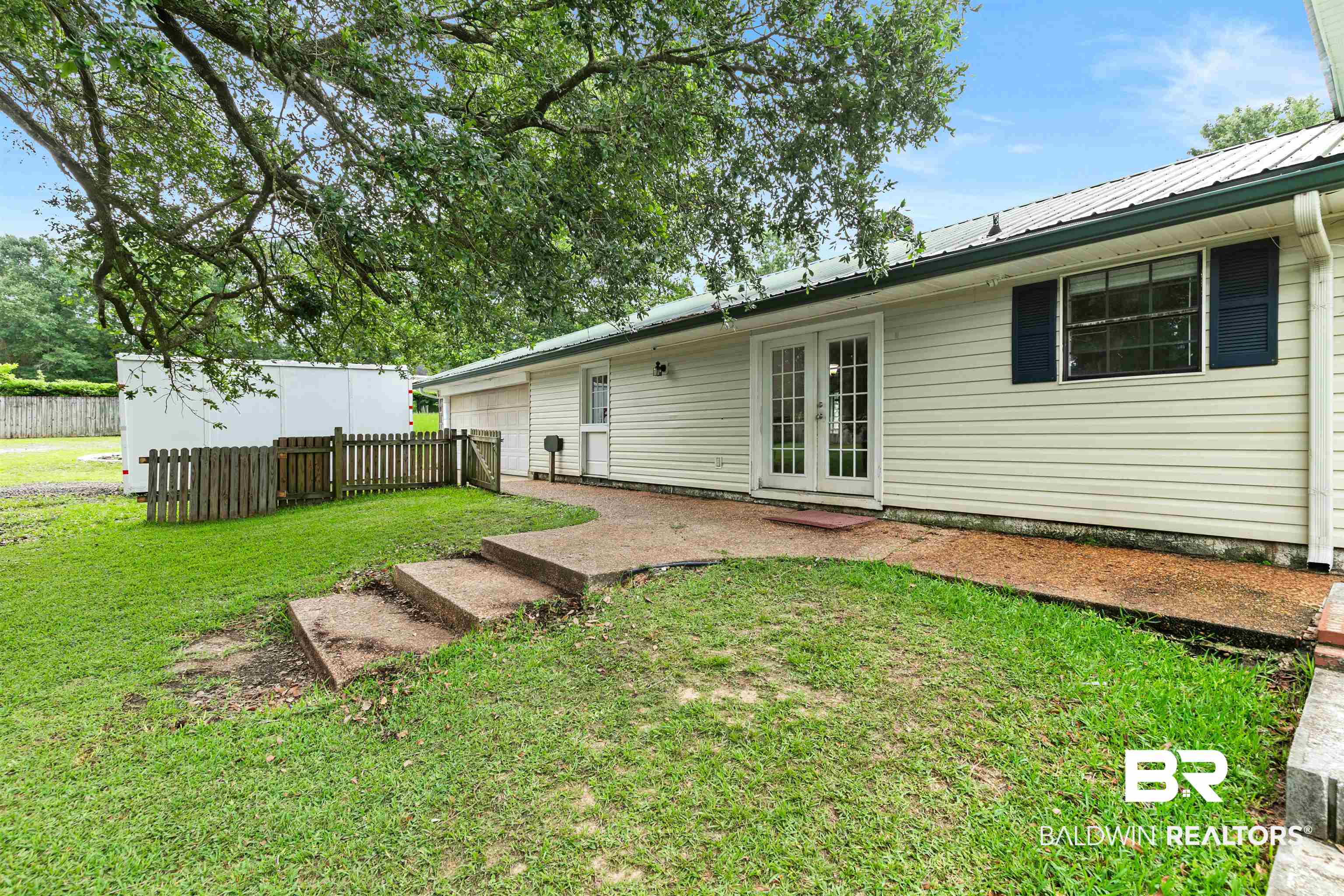 10420 Johnson Road South Mobile, AL 36695 - Photo 62 of 75 Rear exterior featuring light-colored siding, a metal roof, and white French doors