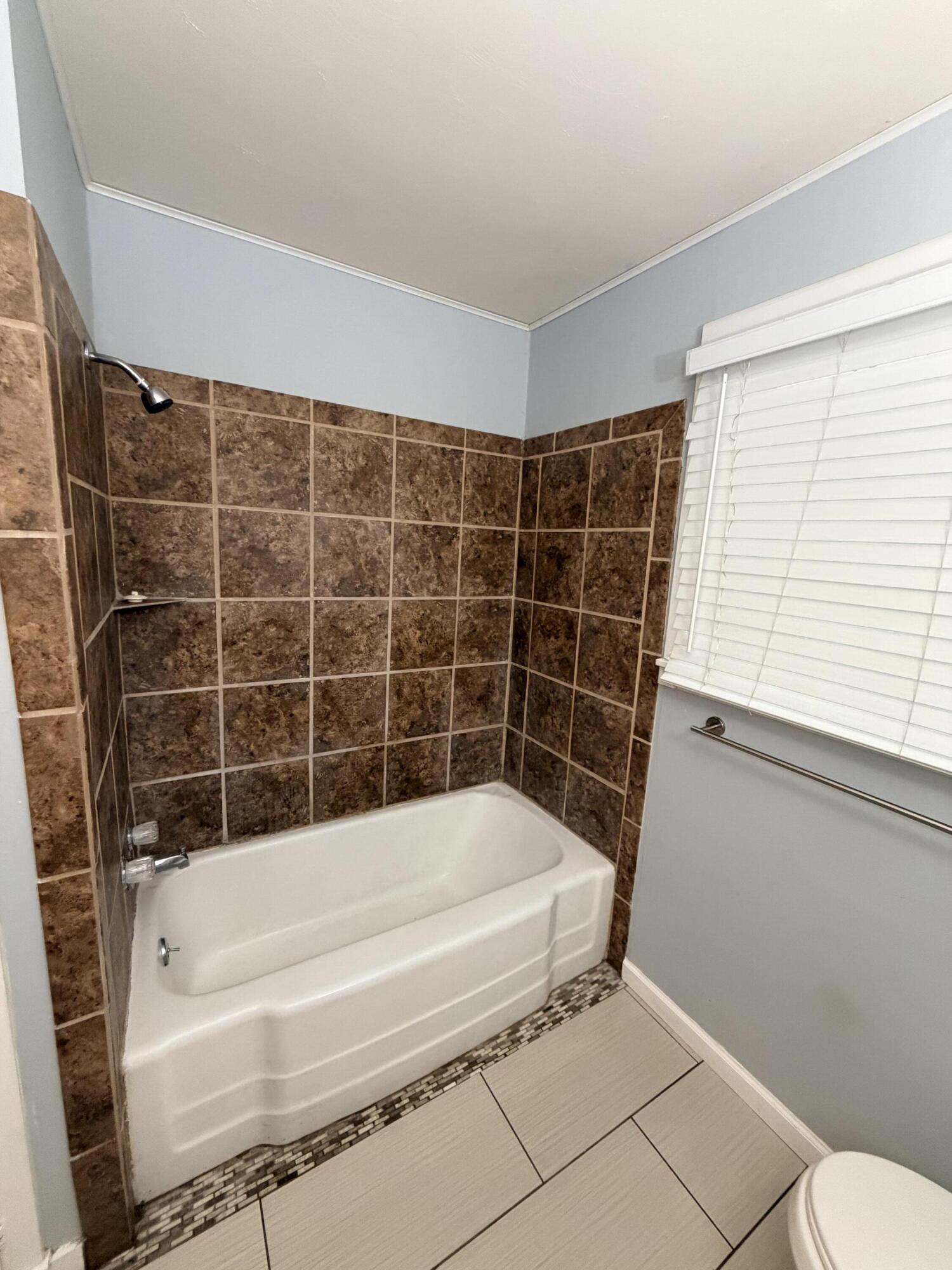 3814 27th Street Lubbock, TX 79410 - Photo 20 of 24 a bathroom with a bathtub and a shower
