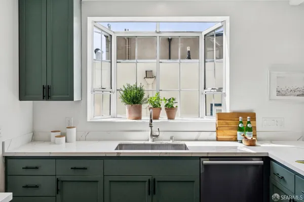 a living room with furniture a window and a potted plant