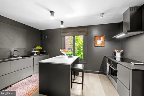 a kitchen with stainless steel appliances kitchen island granite countertop a stove a sink and a microwave