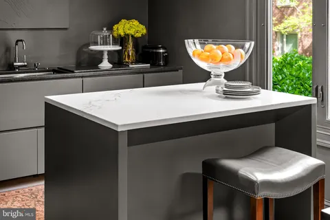 a kitchen with stainless steel appliances kitchen island granite countertop a sink cabinets and wooden floor