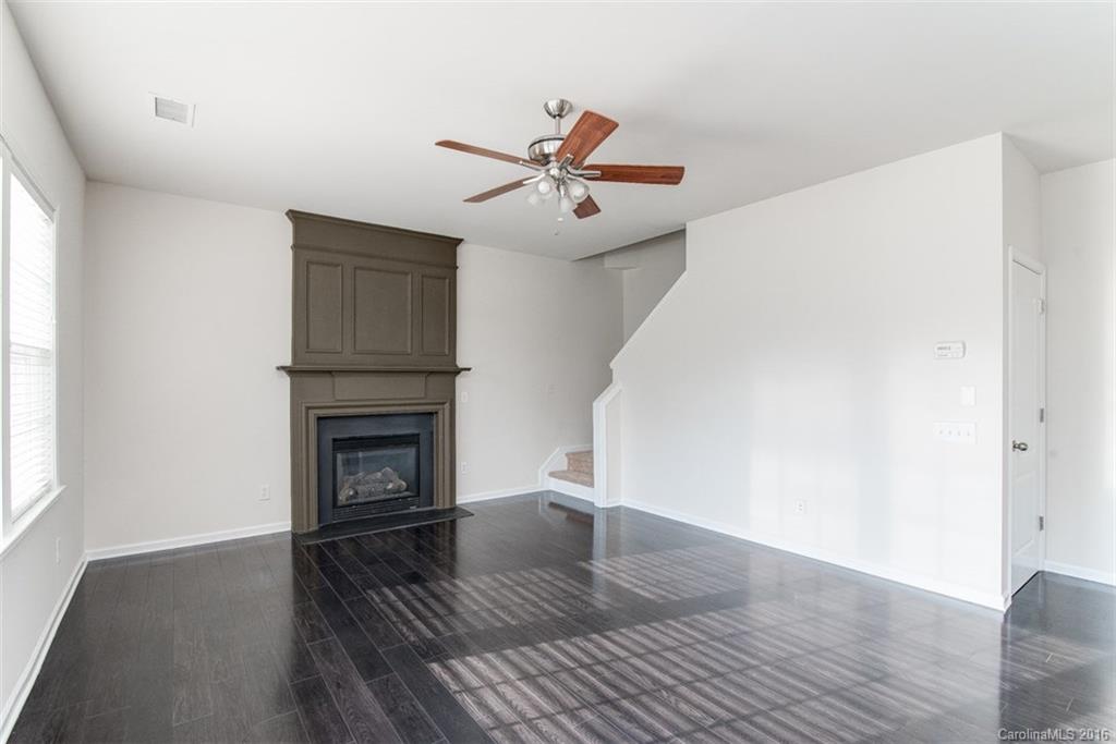 2413 Coltsgate Road Waxhaw, NC 28173 - Photo 13 of 24 a view of a livingroom with a fireplace a ceiling fan and wooden floor