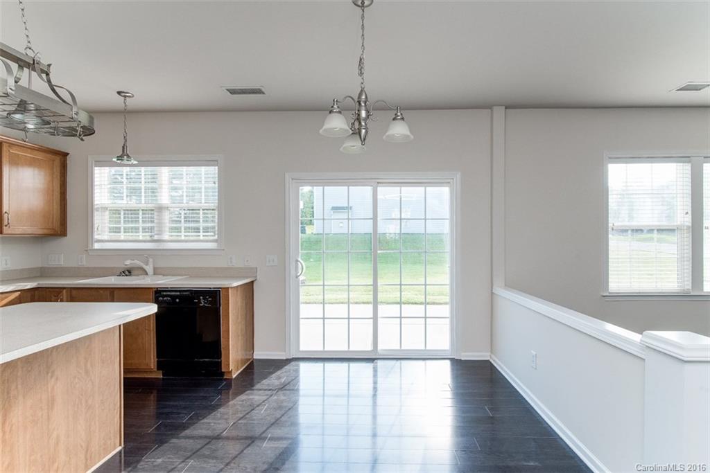 2413 Coltsgate Road Waxhaw, NC 28173 - Photo 4 of 24 a kitchen with stainless steel appliances granite countertop a sink a stove a refrigerator a center island and a window
