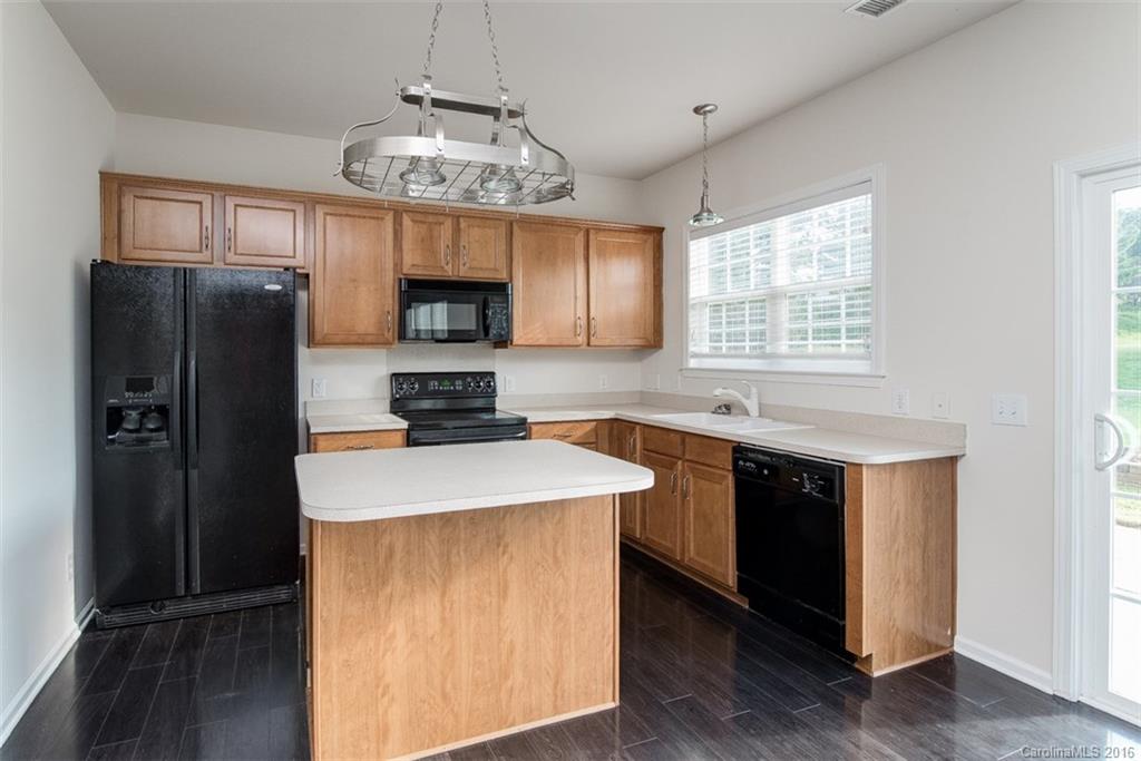 2413 Coltsgate Road Waxhaw, NC 28173 - Photo 6 of 24 a kitchen with stainless steel appliances a refrigerator a stove a sink a center island and a window