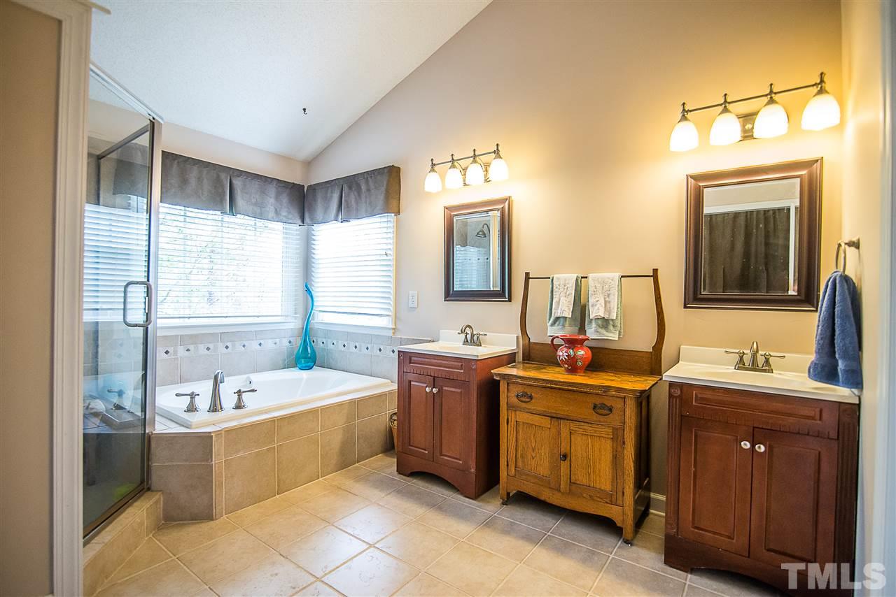 5204 Camfirth Way Raleigh, NC 27613 - Photo 14 of 21 a spacious bathroom with a double vanity sink mirror and bathtub