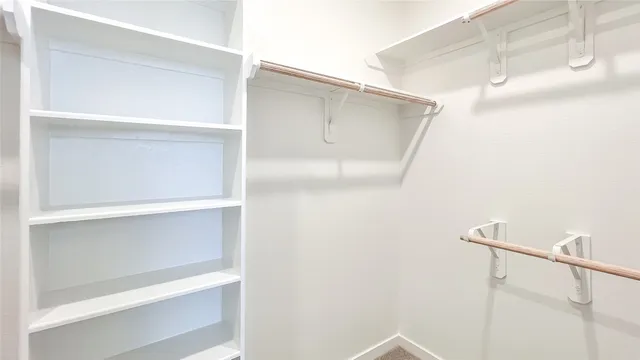 a bathroom with a walk in closet and a shower