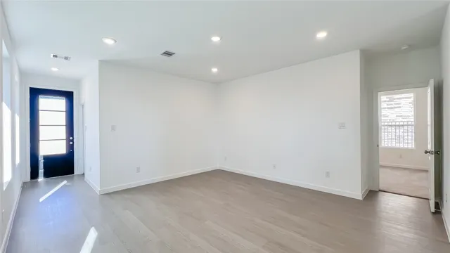 an empty room with wooden floor and entrance